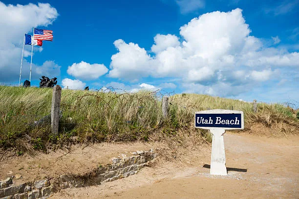 Panneau Utah Beach dans les dunes, avec les drapeaux alliés